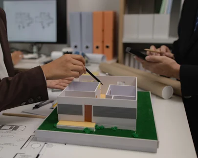Professionals review a building model and blueprints