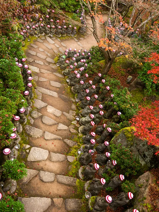 Zen garden with winding path and red-capped statues